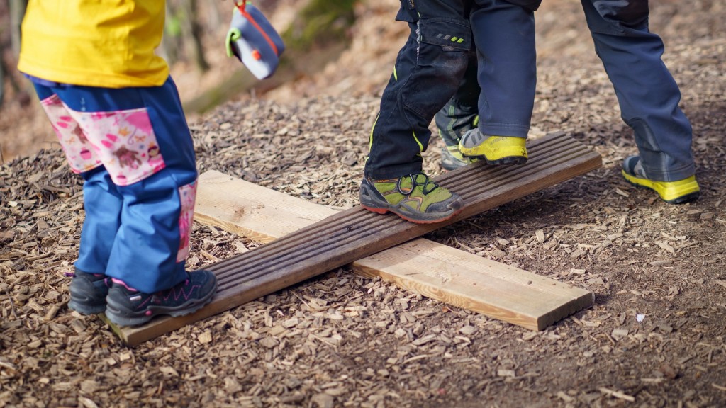 Auf einer einfachen, selbst zusammengesetzten Wippe, spielen Kinder im Waldkindergarten 