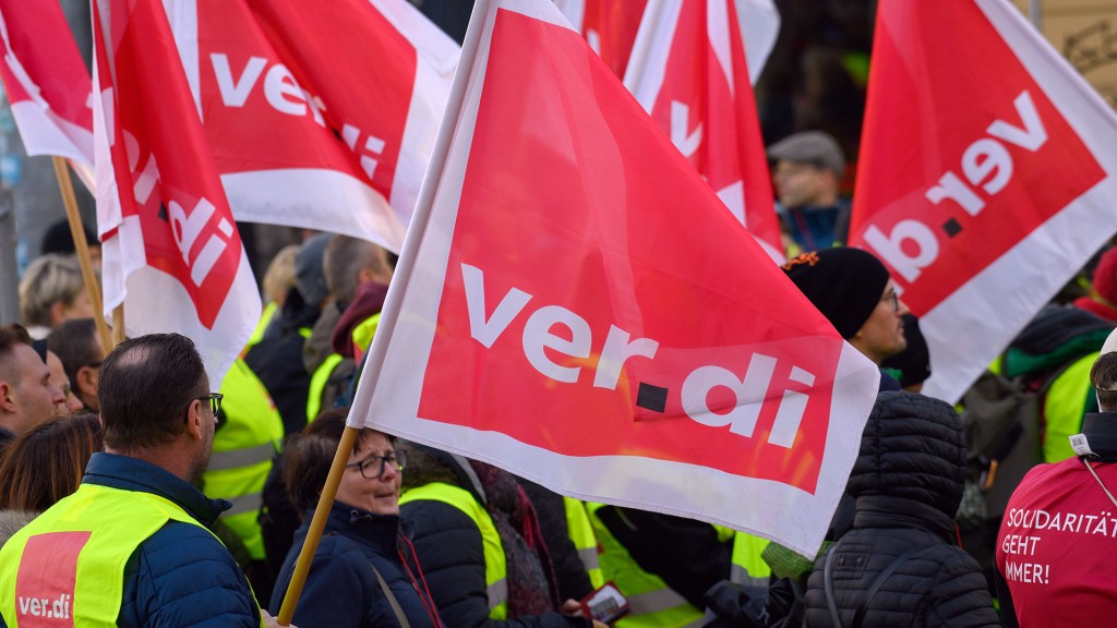 Streikende stehen mit Verdi-Fahnen