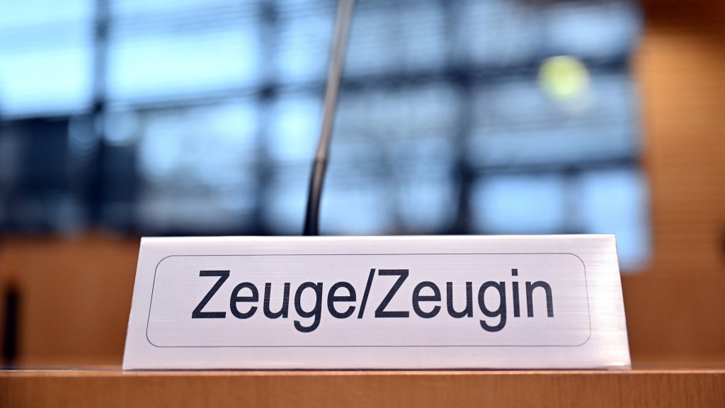 Ein Schild mit der Aufschrift «Zeuge/Zeugin» steht auf einem Tisch.