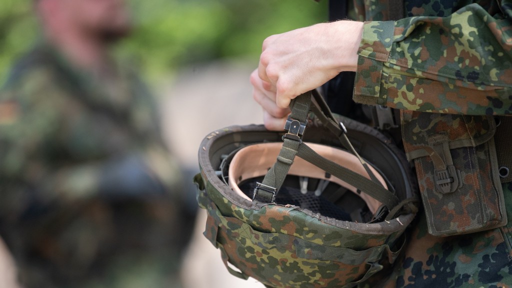 Ein Soldat in Ausbildung hält seinen Helm in der Hand.