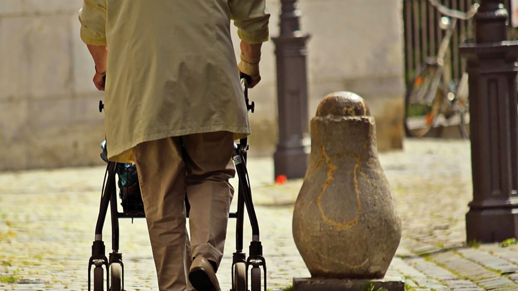 Älterer Mann unterwegs mit einem Rollator