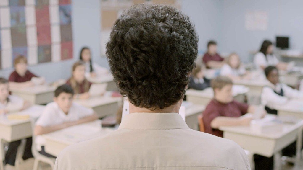 Filmszene aus „Monsieur Lazhar“ von Philippe Falardeau aus dem Jahr 2011: Der algerische Schauspieler Mohamed Fellag in der Rolle des Bashir Lazhar steht mit dem Rücken zum Betrachter vor einer Schulklasse. 