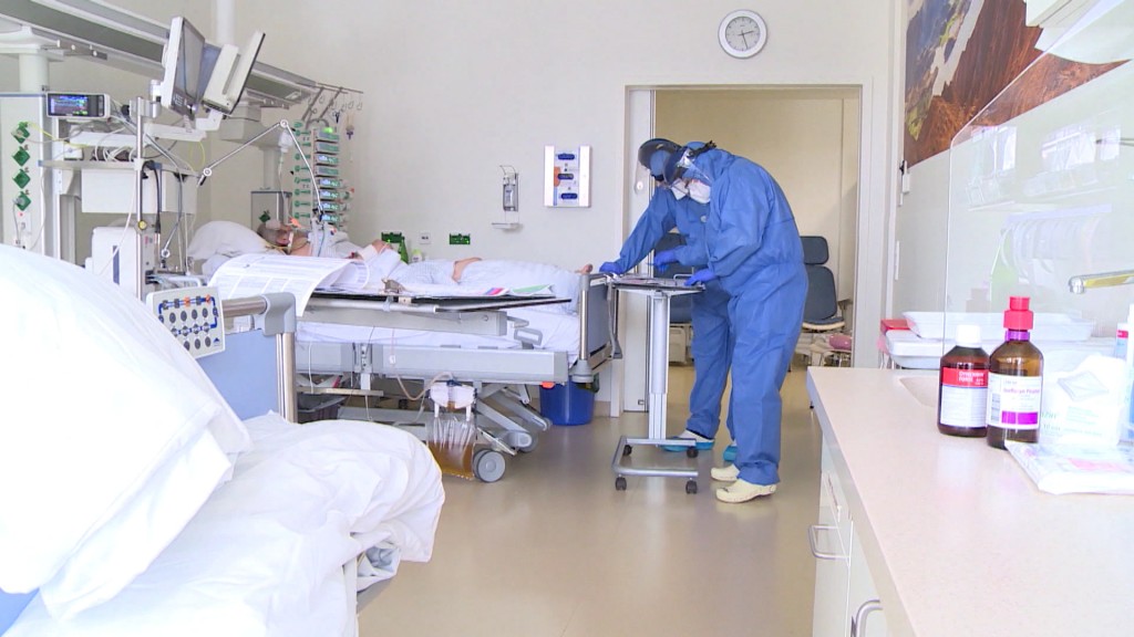 Zwei Ärzte stehen bei einem Patienten