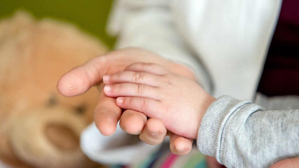 Ein Arzt hält die Hand eines kleinen Kindes 