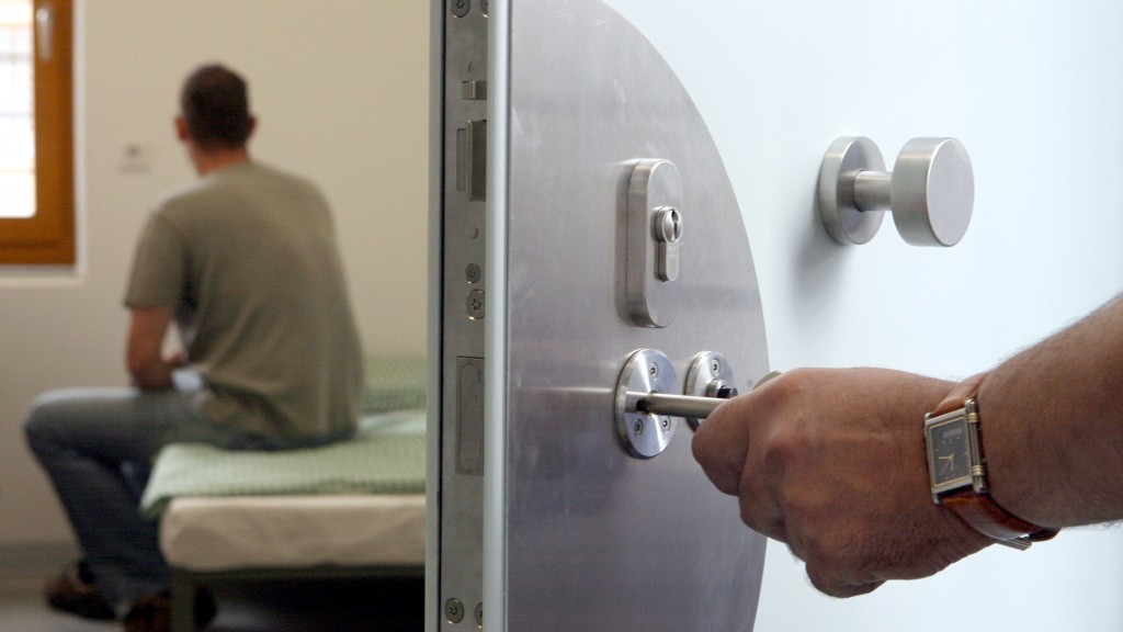 Ein Justizbeamter öffnet die Tür zur Haftzelle eines Insassen