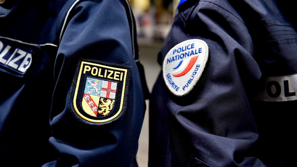 Foto: Abzeichen auf den Uniformen eines saarländischen und eines französischen Polizisten