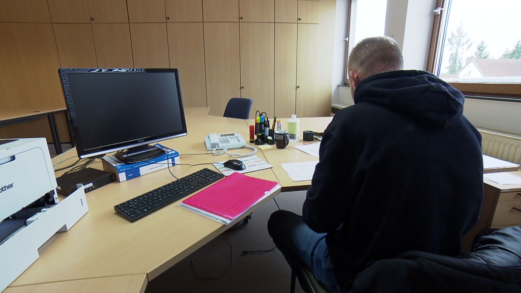 Foto: Ein Angestellter im Kirkeler Rathaus sitzt nach einem Hackerangriff auf die Computersysteme an seinem Schreibtisch vor schwarzem Bildschirm