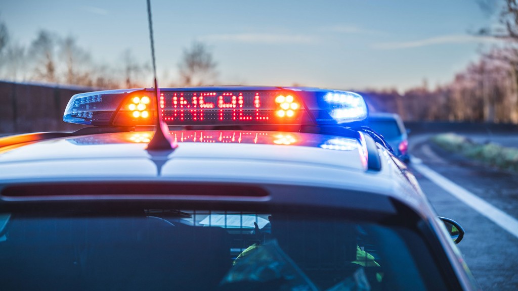 Ein Polizeifahrezug sichert mit Blaulicht eine Unfallstelle ab