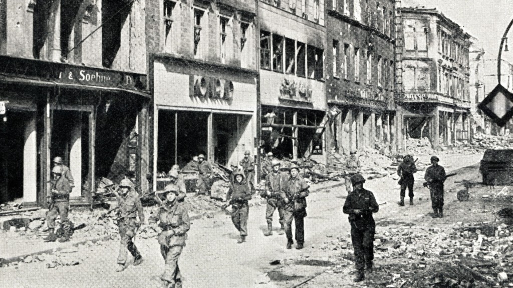 US-Truppen maschieren im März 1945 durch die heutige Eisenbahnstraße in Saarbrücken, auf der Suche nach letzten deutschen Scharfschützen