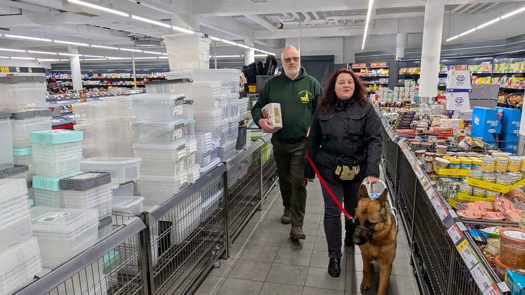 Trainer Roland Schmitz, Melanie und Blindenführhund Jack beim Einkaufen