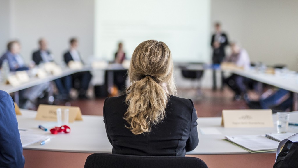 Frauen im Führungspositionen. Eine Frau sitzt in einem Meeting.