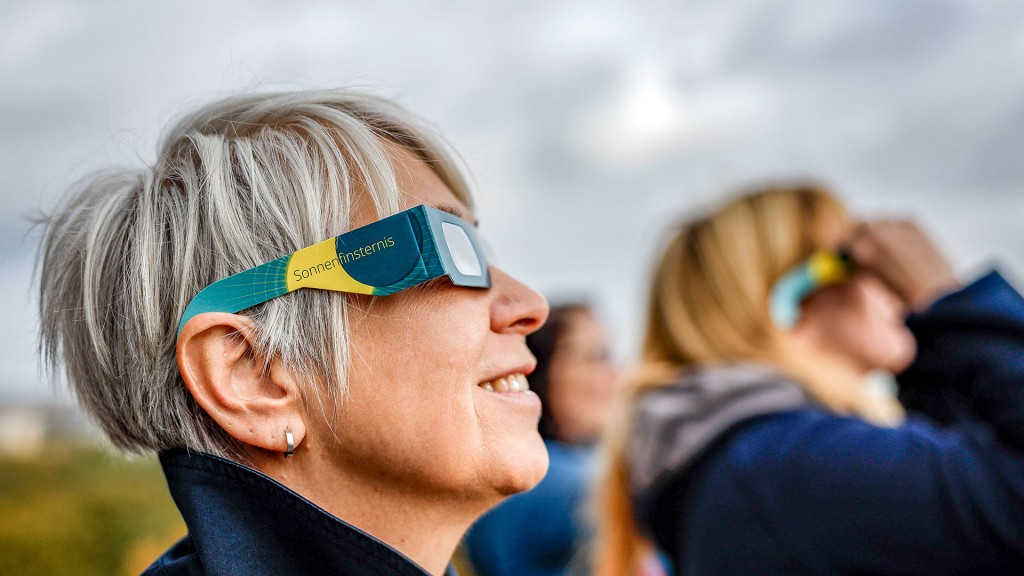 Menschen beobachten eine partielle Sonnenfinsternis mit Schutzbrillen