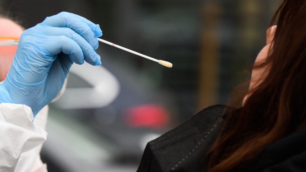 Eine Mitarbeiterin nimmt einen Abstrich von einer Patientin