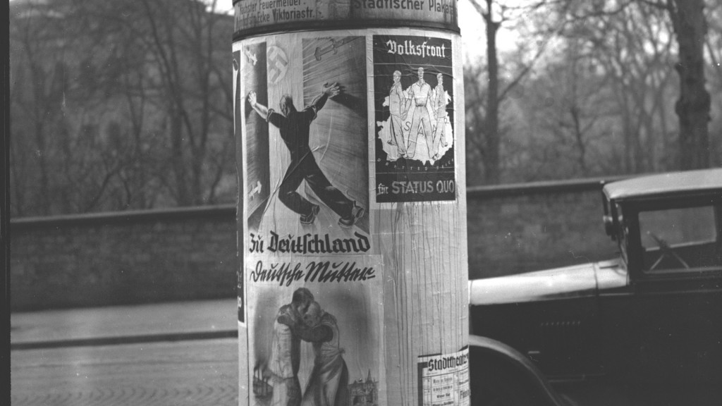 Eine Litfaßsäule mit Plakaten von Deutscher Front und Status-Quo-Anhängern