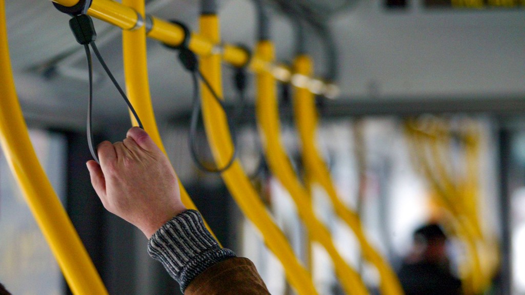 Ein Fahrgast hält sich im Bus an einer Halteschlaufe fest