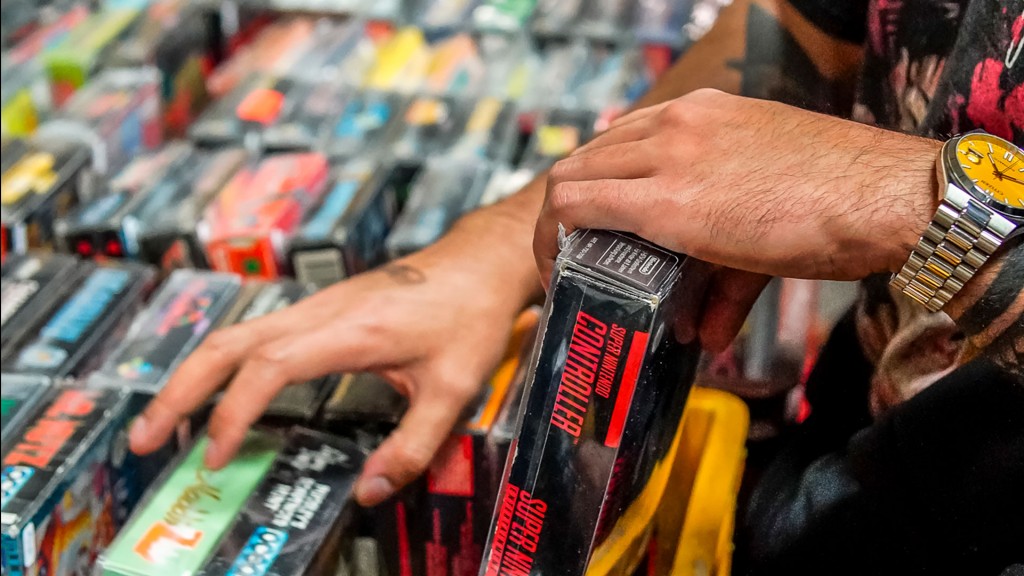 Hände durchsuchen das Angebot an Spielen bei der RetroCon Saar