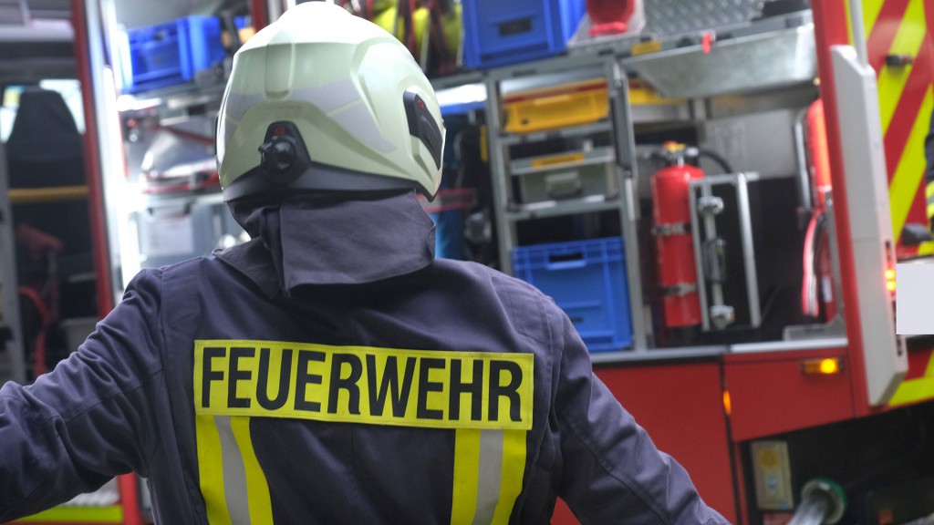 Ein Feuerwehrmann steht vor dem Gerätewagen