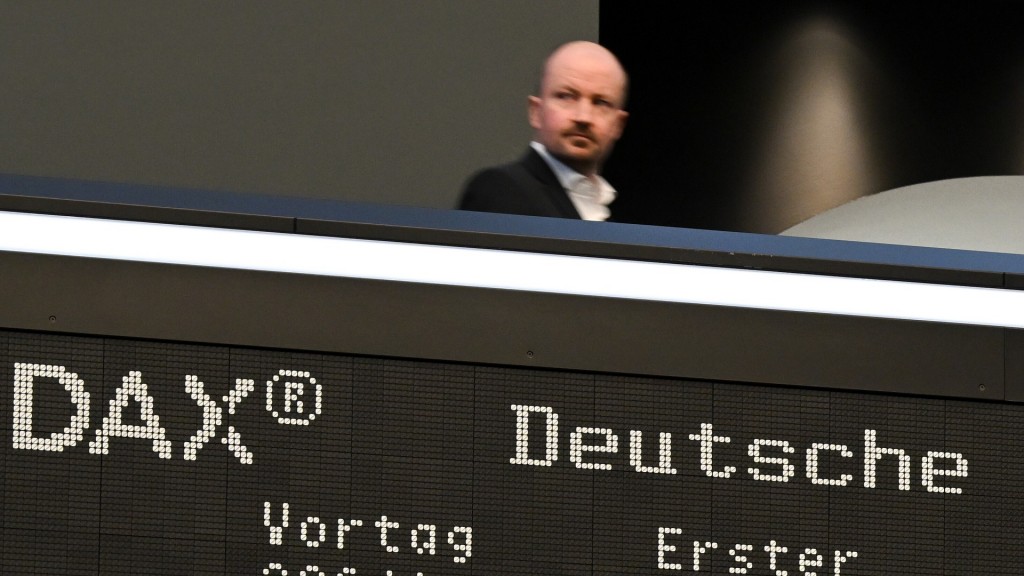 Während ein Besucher auf der Empore der Frankfurter Wertpapierbörse steht, zeigt die Anzeigetafel mit der Dax-Kurve einen starken Verlust an.