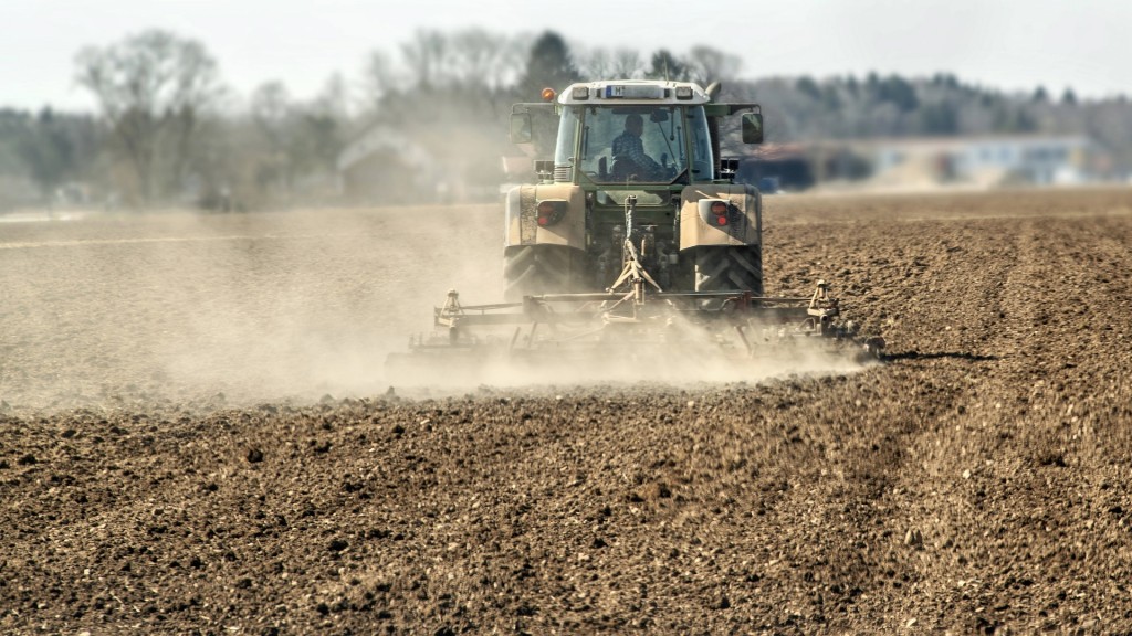 Landwirt mit Traktor auf dem Acker wirbelt Staubwolken auf