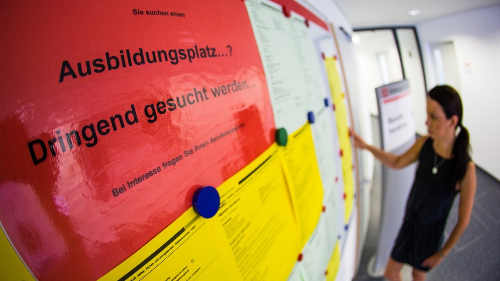 Eine junge Frau schaut sich Aushänge mit freien Ausbildungsplätzen an.