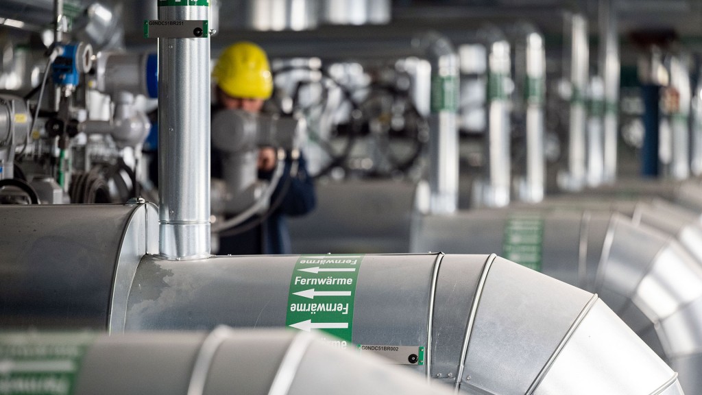 Foto: Ein Techniker kontrolliert Wärmeleitungen in einem Heizkraftwerk