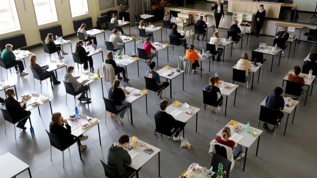 In einer Aula sitzen die Schüler an auseinandergestellten Tischen in der schriftlichen Abiturprüfung.