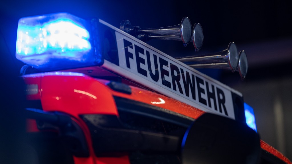 Ein Einsatzfahrzeug der Feuerwehr steht mit Blaulicht bei der Feuerwache