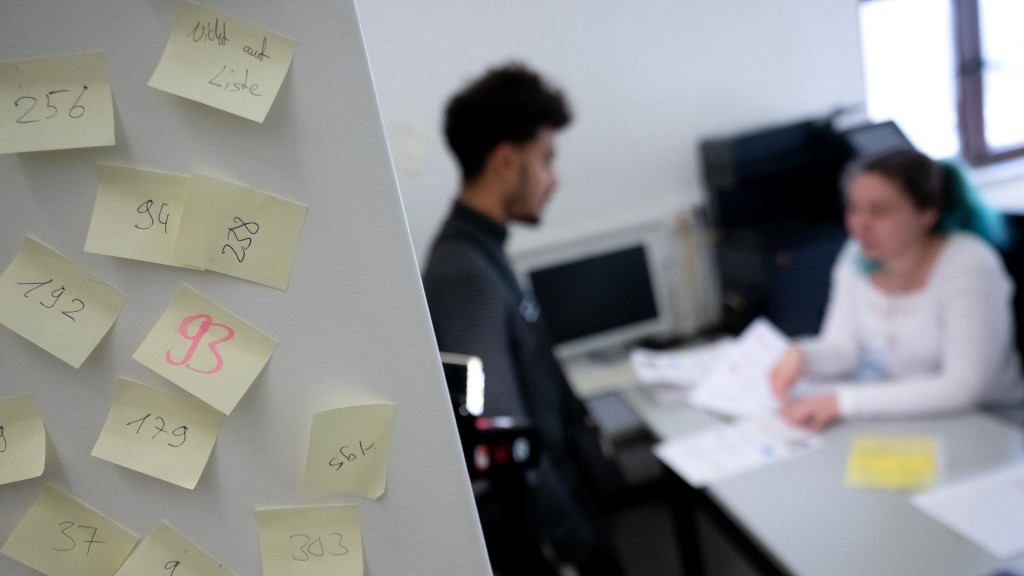 Ein Asylbewerber sitzt in einem Büro und wird von einer Sachbearbeiterin beraten