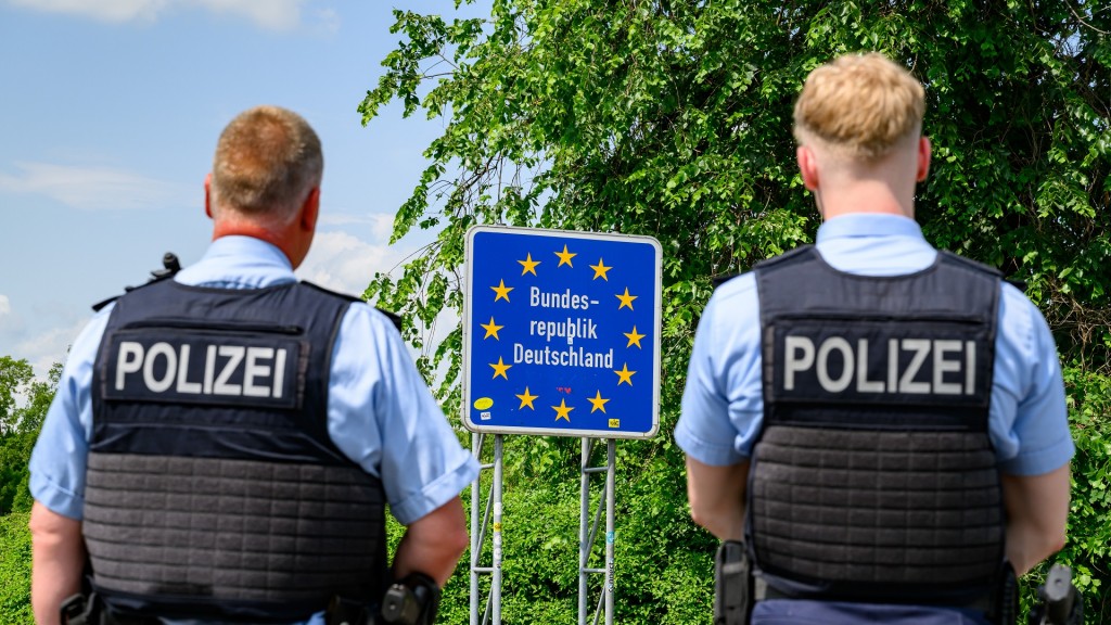 Zwei Bundespolizsten stehen vor einem Schild auf dem 
