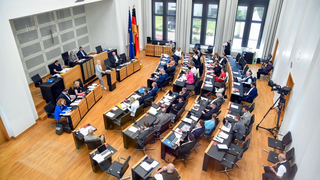 Abgeordnete sitzen im Plenarsaal des saarländischen Landtags währen einer Sitzung