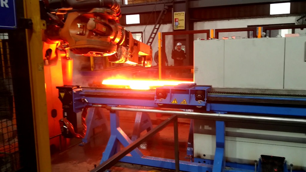 Foto: Roboterarm bearbeitet glühend heißes Metallstück