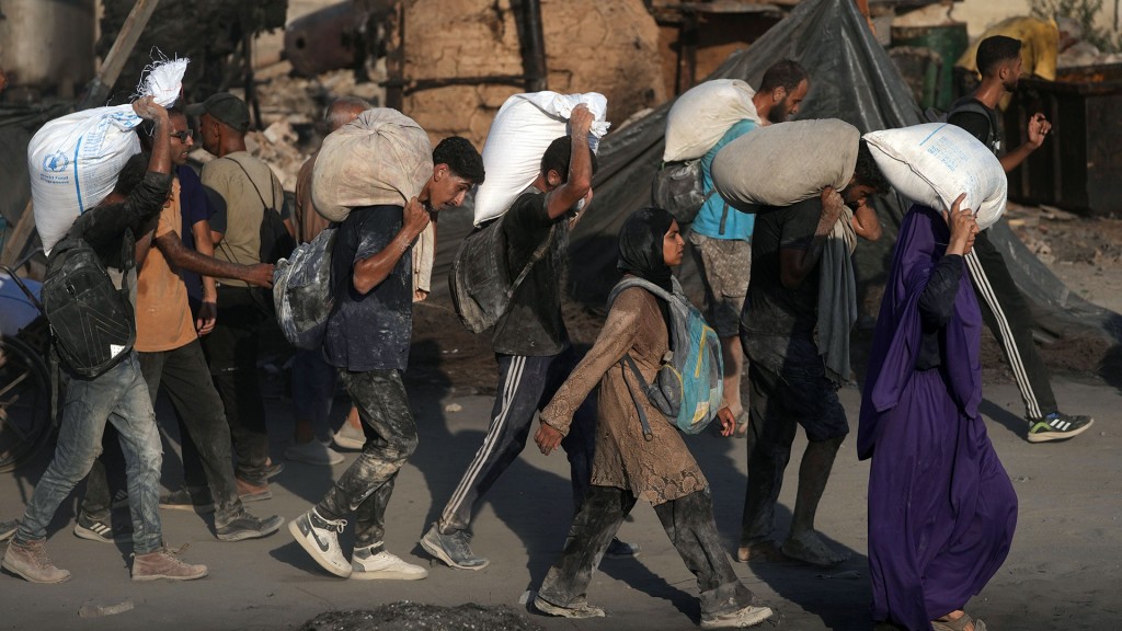 Palästinenser tragen Mehlsäcke, die von einem humanitären Hilfskonvoi geliefert wurden, der Gaza-Stadt aus dem nördlichen Gazastreifen erreichte, 26.07.2025