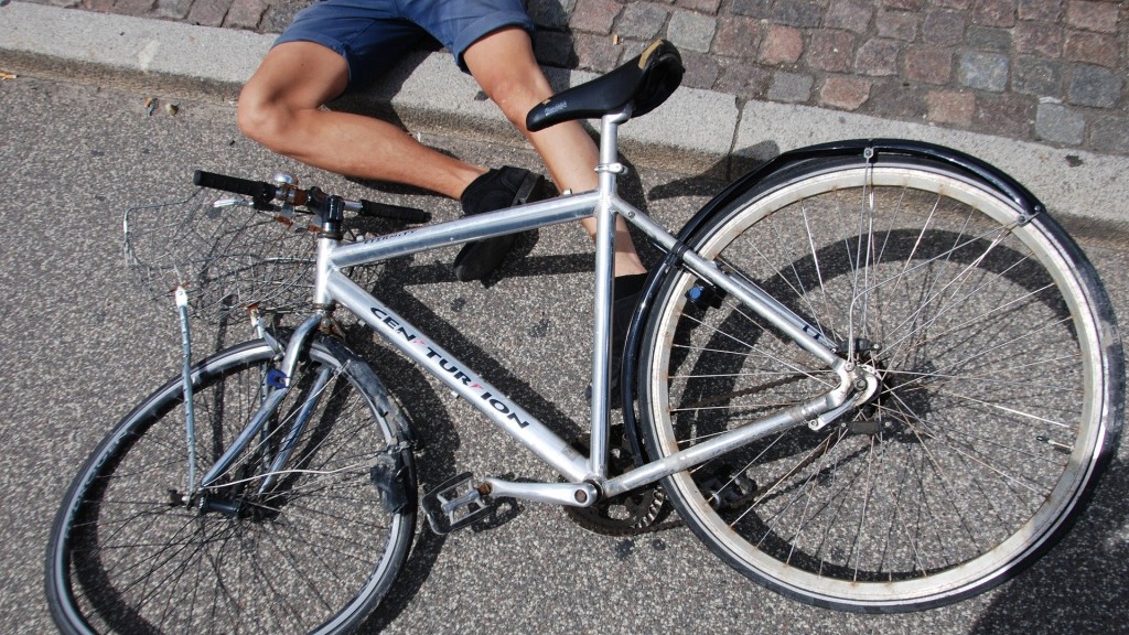 Symbolbild: Ein Mann liegt nach einem Unfall unter seinem verbeulten Fahrrad