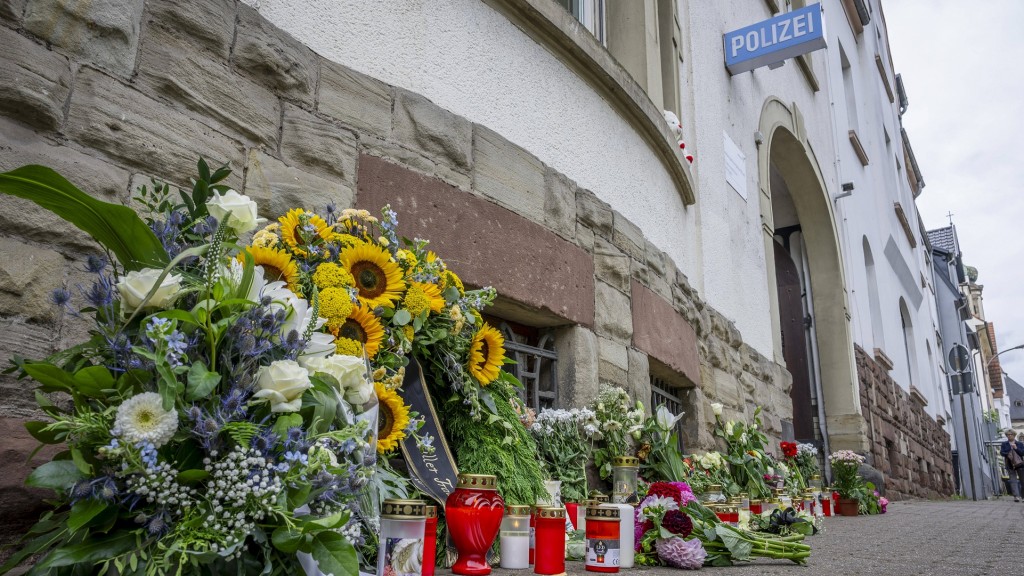 Ein Meer aus Blumen und Kerzen liegt vor der Polizeiinspektion Völklingen