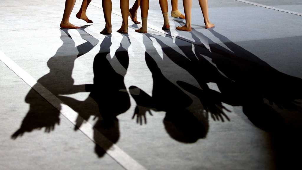 Schatten mehrerer Sportlerinnen auf einem Turnhallenboden