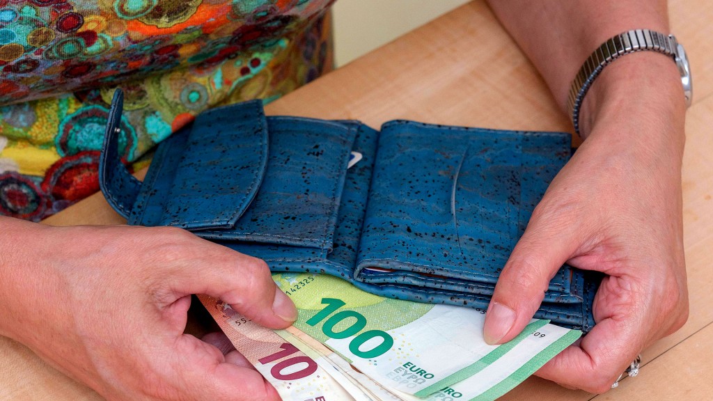 Eine Frau zieht Geldscheine aus ihrem Portemonnaie