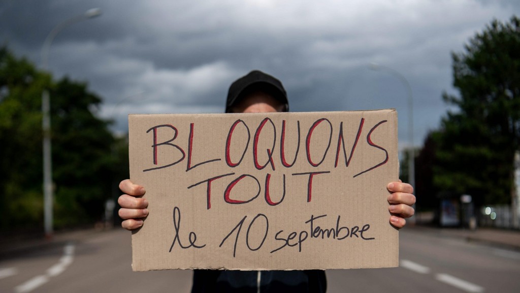 Protestaktion in Frankreich. Eine Person hält ein Schild mit der Aufschrift 