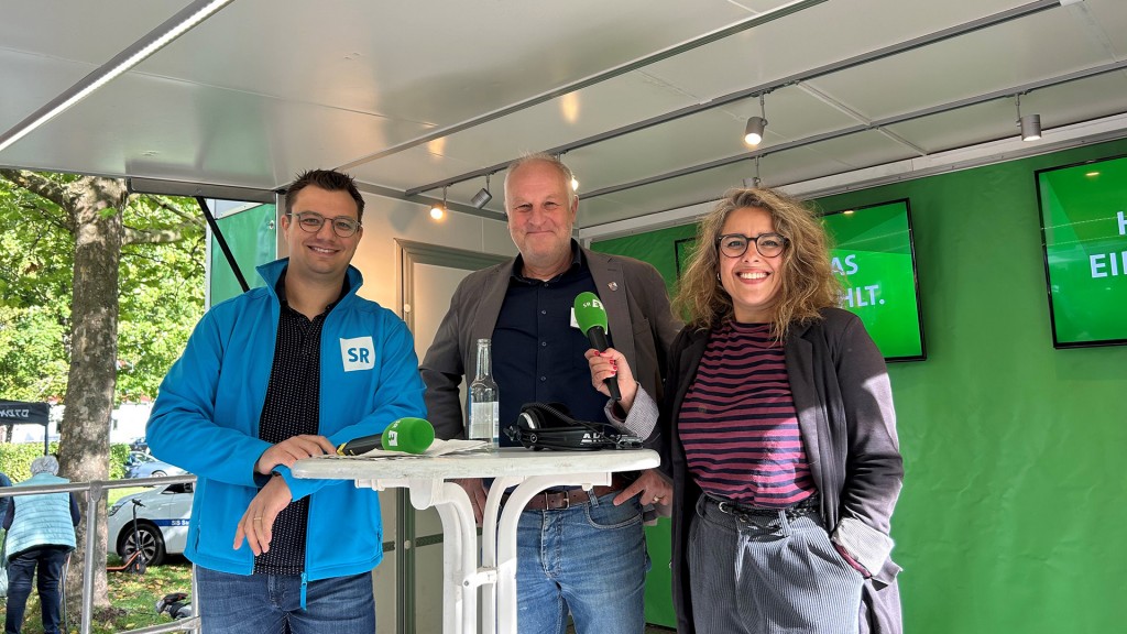 SR Reporter Oliver Buchholz, Bürgermeister Stephan Barth, SR Reporterin Simin Sadeghi