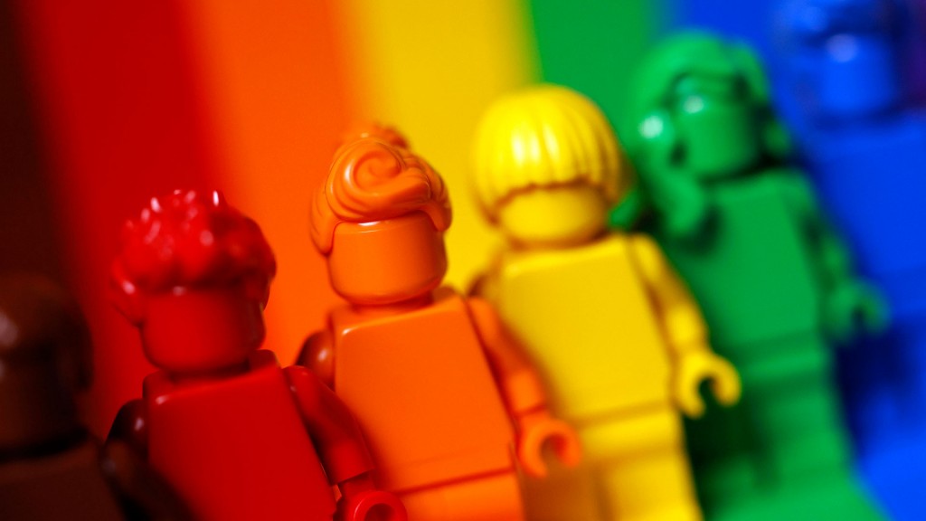 Bunte Figuren stehen in Regenbogenfarben nebeneinander