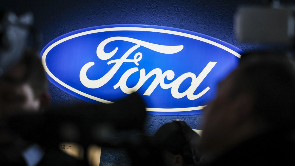 Foto: Ein beleuchtetes Firmenschild des Autobauers Ford leuchtet am Rande einer Betriebsversammlung