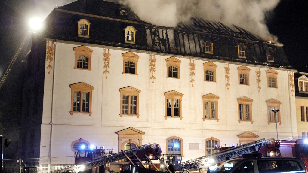 Löschfahrzeuge der Feuerwehr vor dem noch qualmenden Dachstuhl der Anna Amalia Bibliothek in Weimar