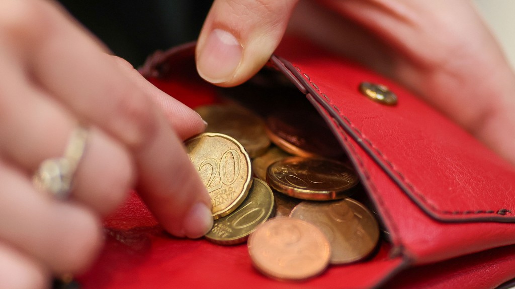 Jemand kramt Cent-Münzen aus einem Geldbeutel