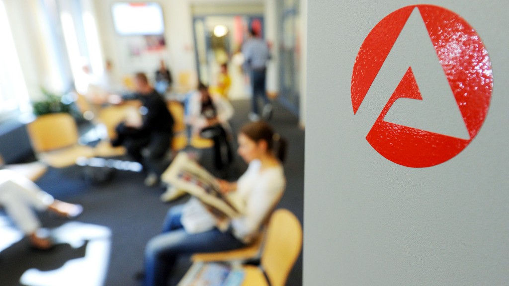 Menschen sitzen im Wartebereich der Agentur für Arbeit