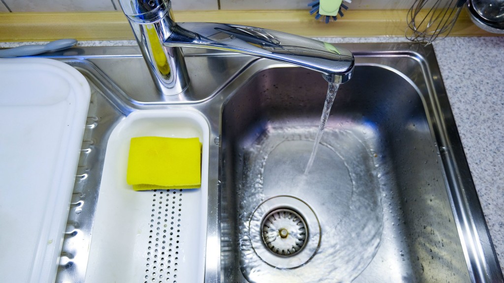 Wasser läuft aus dem Hahn in eine Küchenspüle