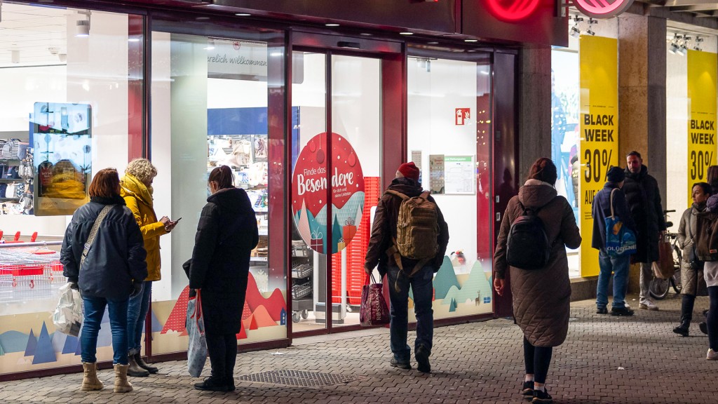 Foto: Passanten und Kunden vor dem Schaufenstern einer Ladenzeile