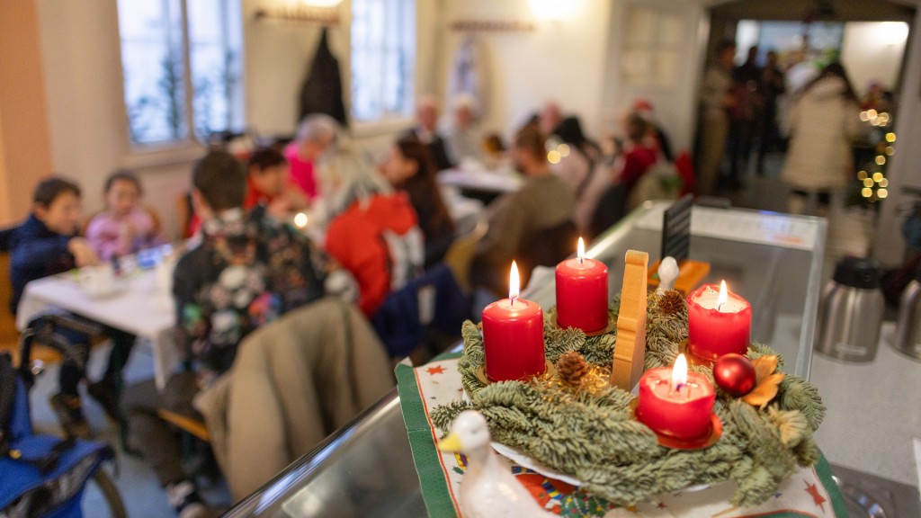 Vier Kerzen brennen an einem Adventskranz bei einer Weihnachtsfeier 
