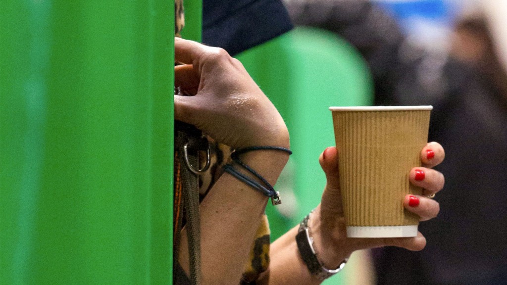 Foto: Eine Frau hält einen Getränkebecher aus Pappe in der Hand