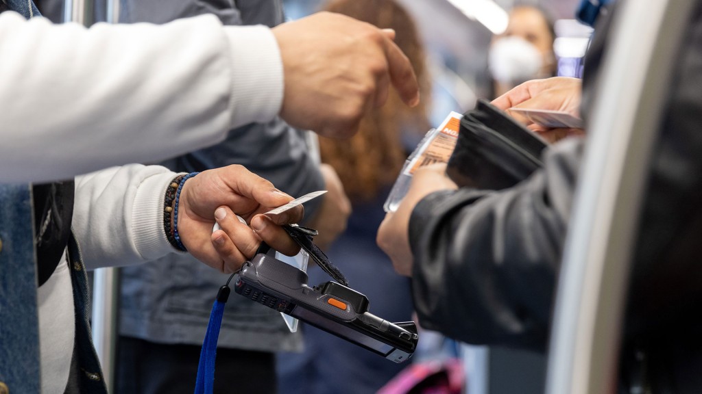 Ein Fahrkartenkontrolleur kontrolliert den Fahrschein von einem Fahrgast