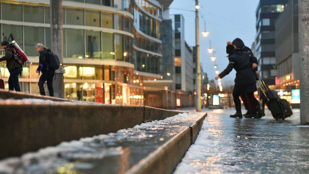 Foto: Fußgänger mit Koffern und Taschen auf vereistem Weg zum Saarbrücker Hauptbahnhof