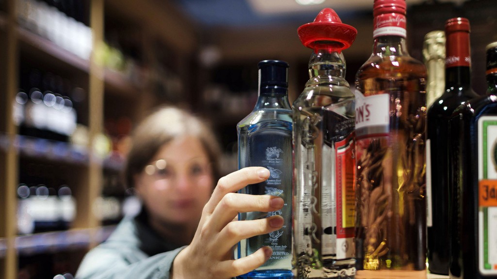 Eine junge Frau greift im Supermarkt nach alkoholischen Getränken.
